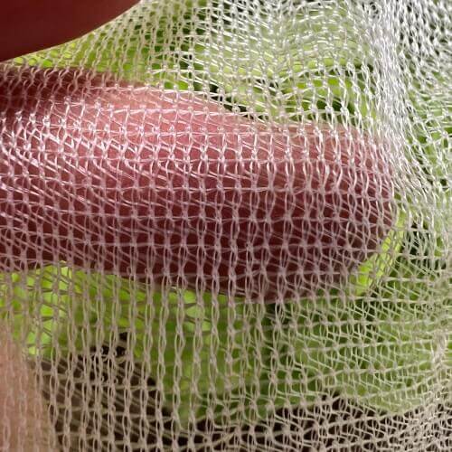 Close up of biodegradable netting with hand underneath