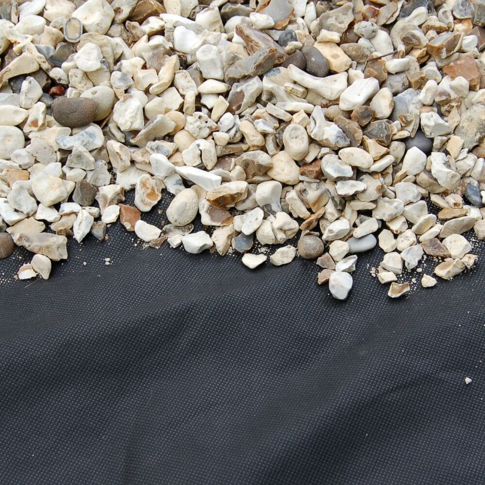 Small stones on a black textured weed fabric surface