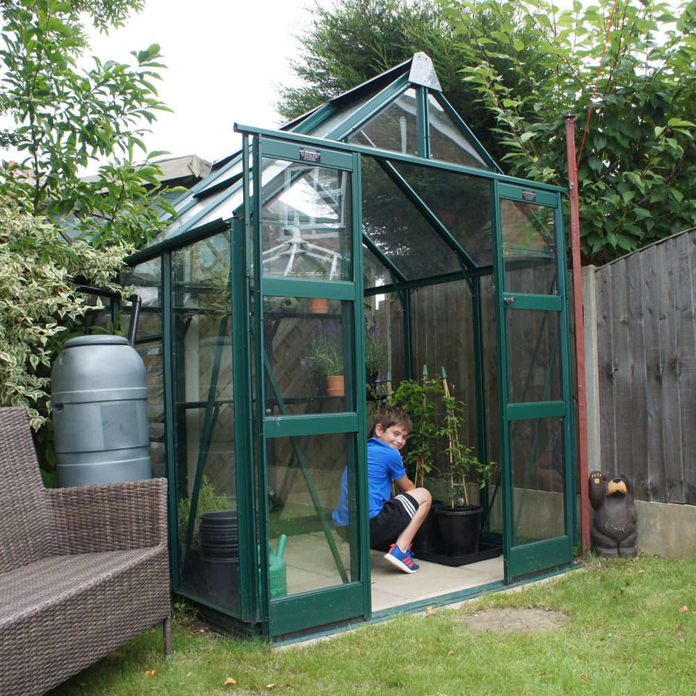 boy in green framed greenhouse