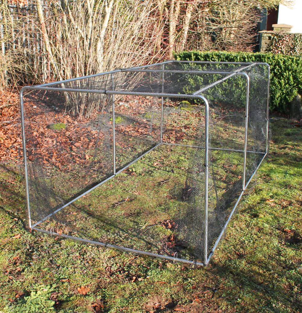 Metal garden cage on grass with trees in the background