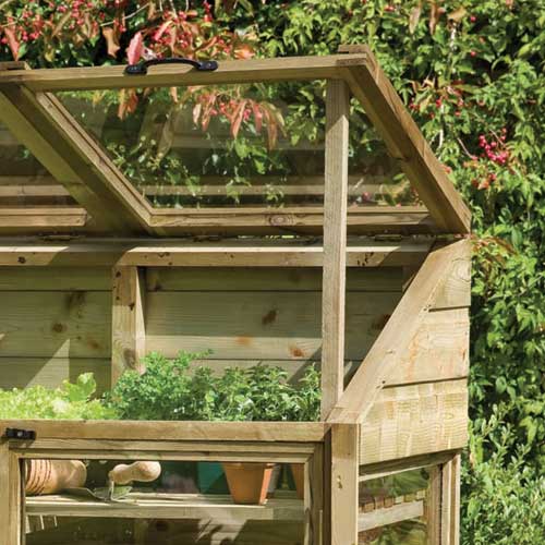 Close up of mini greenhouse with roof up in garden