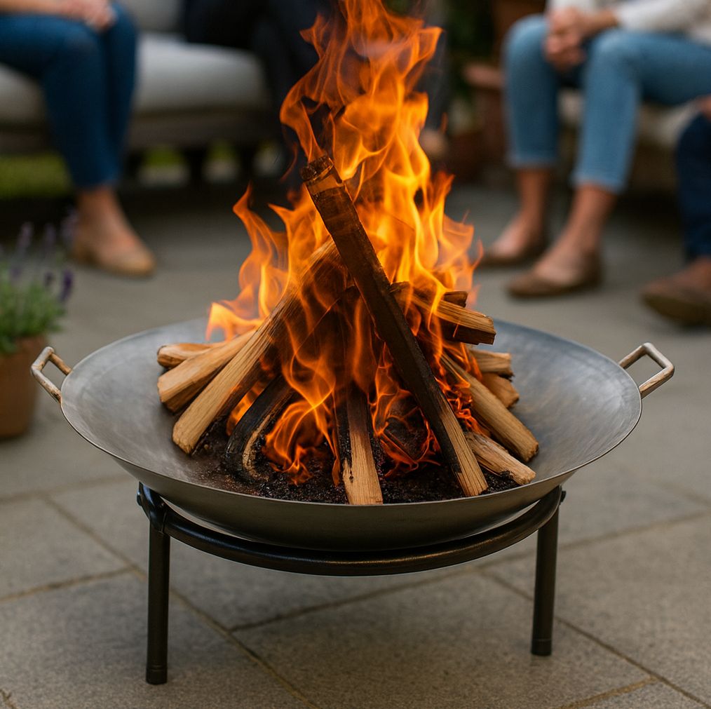 Fire pit with burning wood on a patio, people sitting in the background