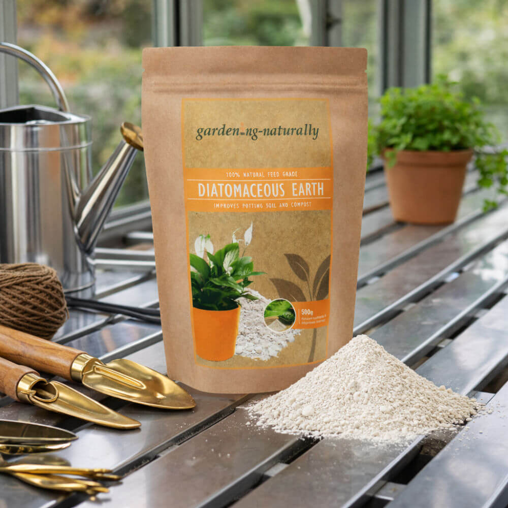 Package of diatomaceous earth with gardening tools and plants on a table