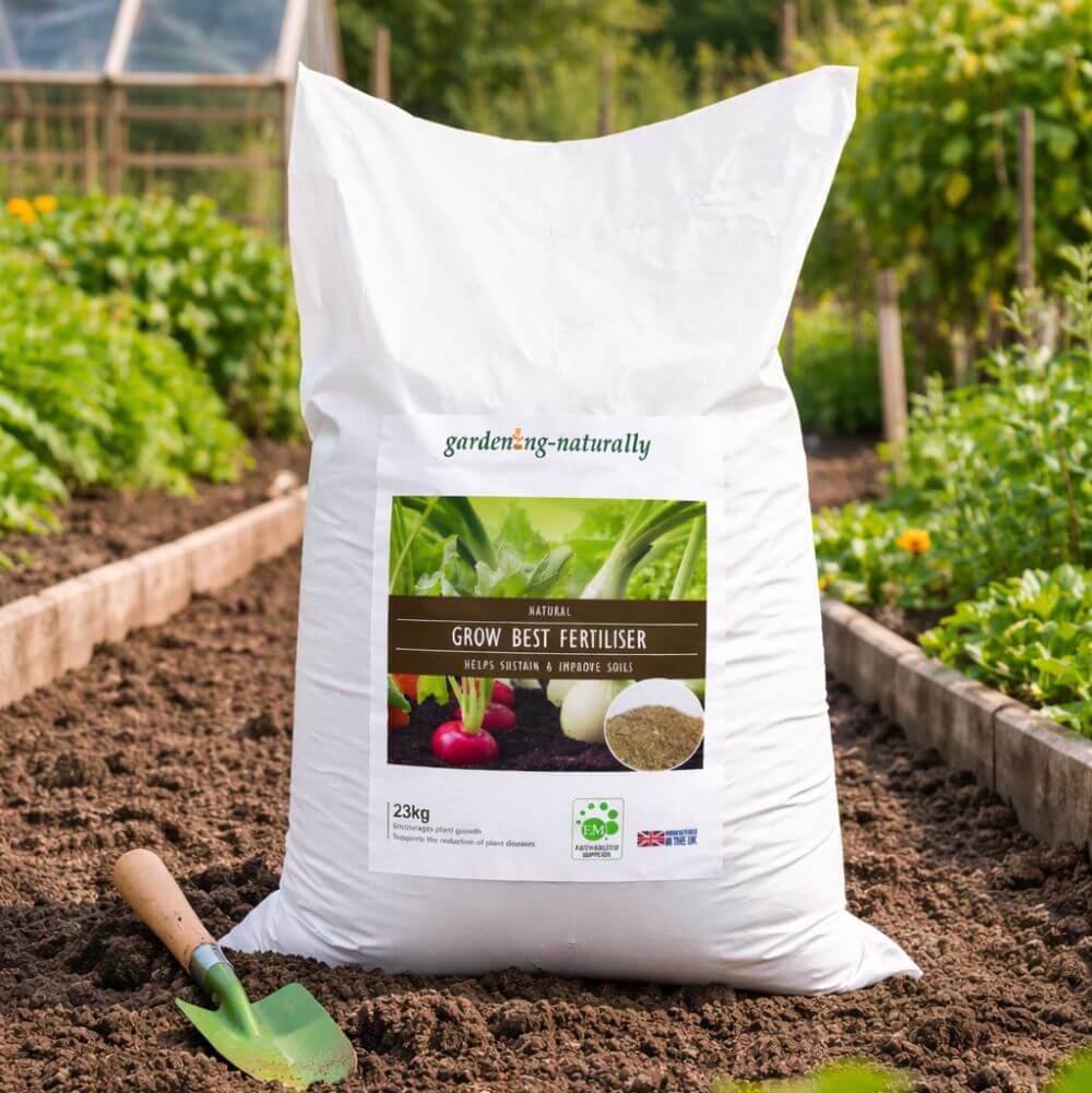 Bag of gardening fertilizer labeled 'Grow Best Fertiliser' in a garden setting