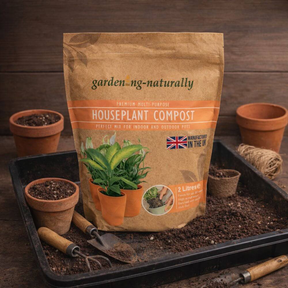 Bag of houseplant compost with gardening tools and pots on a wooden background