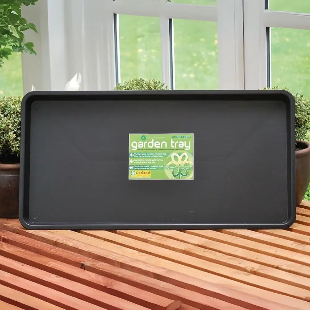 Long black garden tray sat on wooden bench