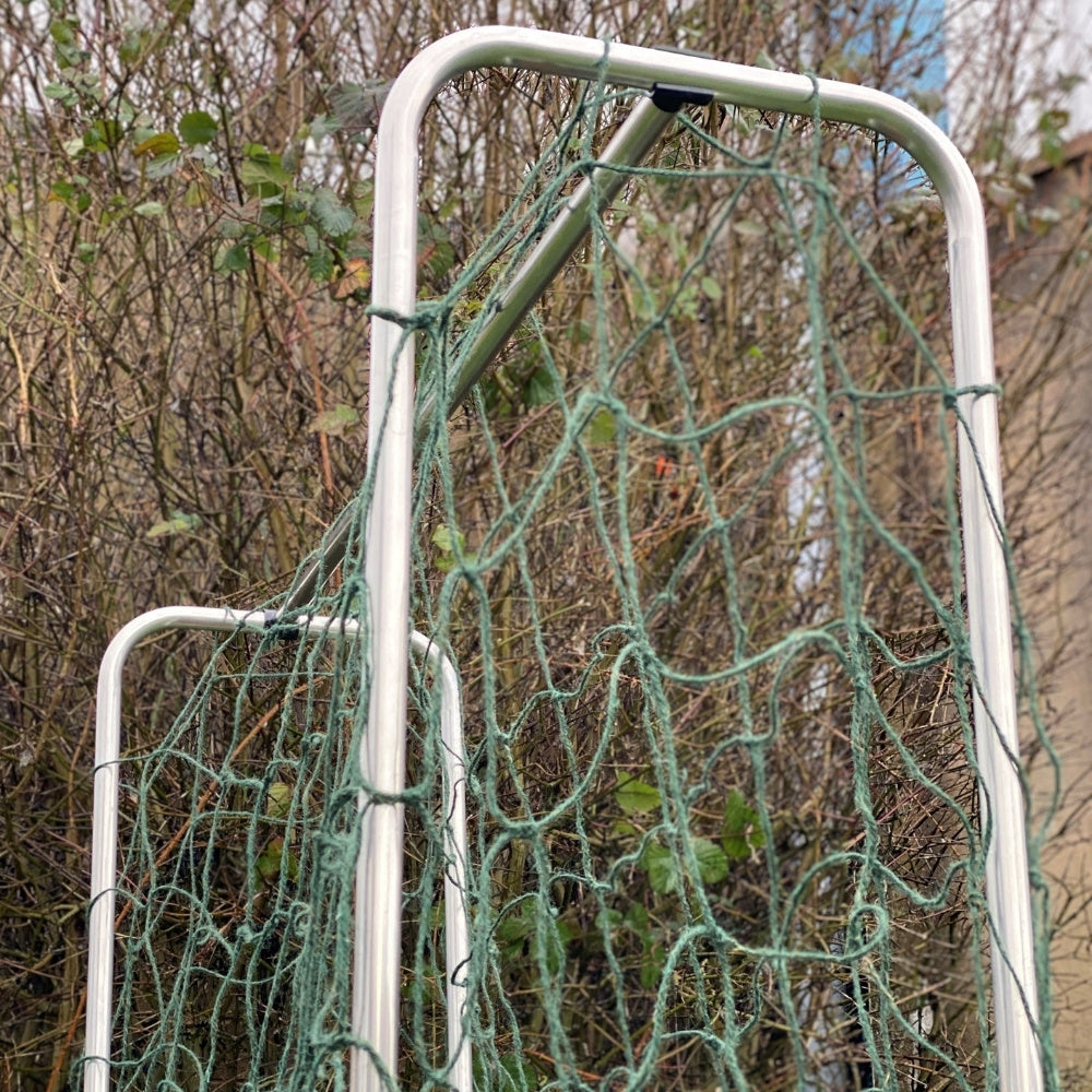 Metal frame with green netting against a natural background