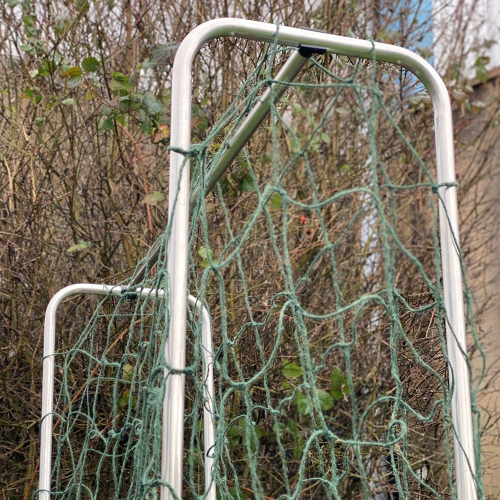 Metal frame with green netting against a natural background for growing peas and beans