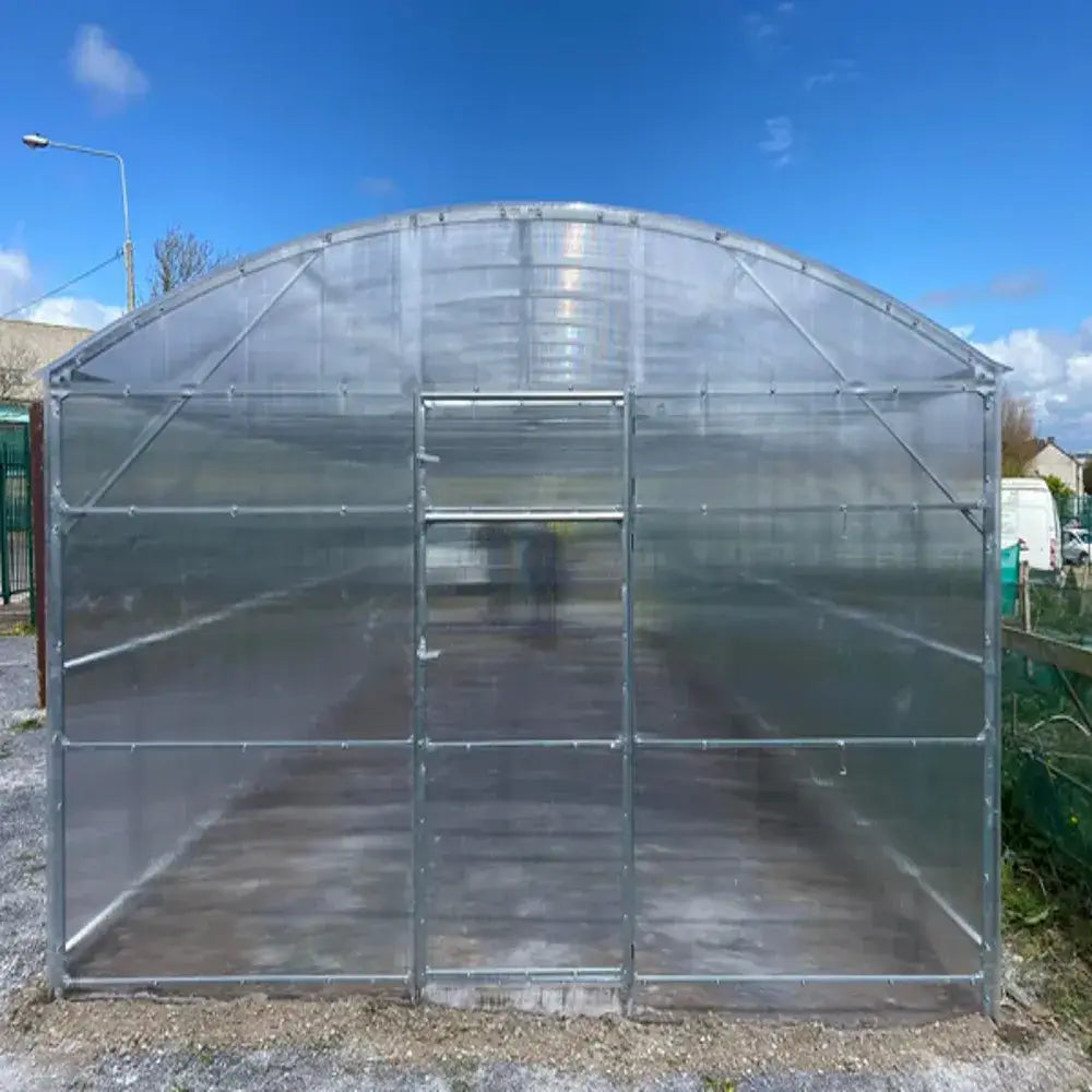 Clear polycarbonate greenhouse with a blue sky background