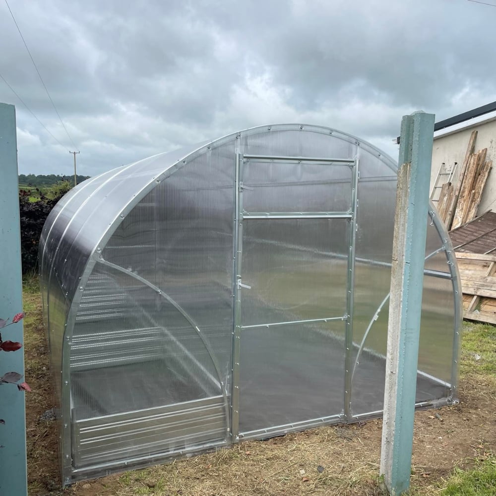 cloes up of greenhouse polytunnel with planters inside