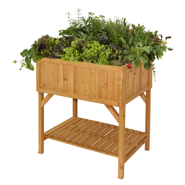 A wooden VegTrug raised bed planter filled with various plants and placed with a lower shelf for additional planters or tools.